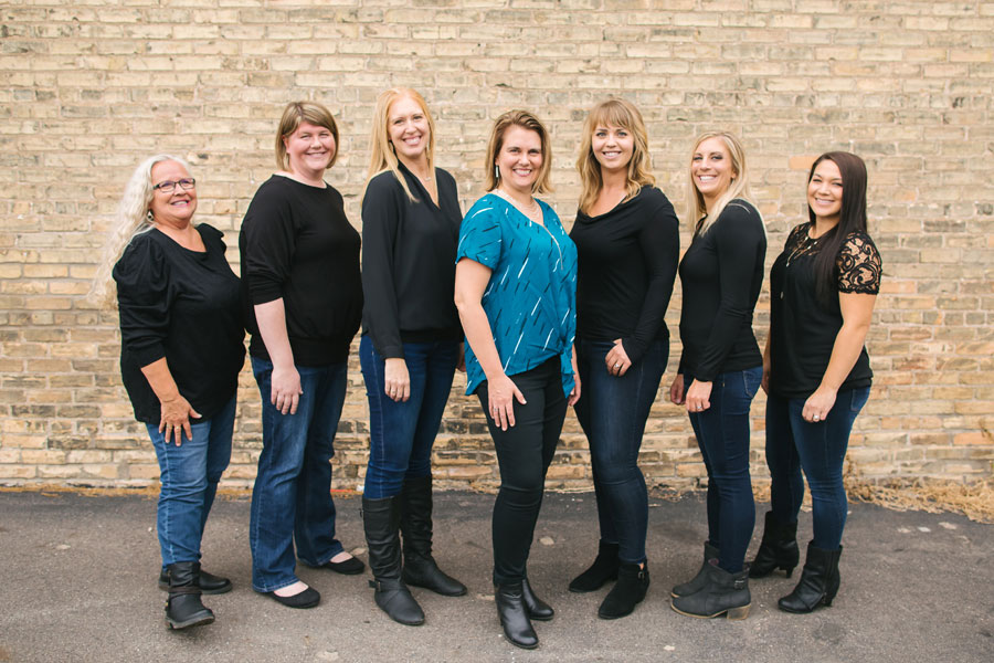 dh Dental Care team group shot in front of a brick wall